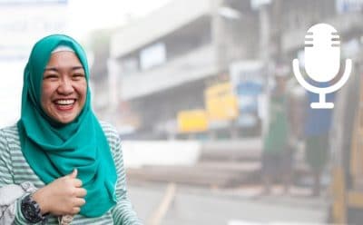 Woman in headscarf laughing in front of street construction