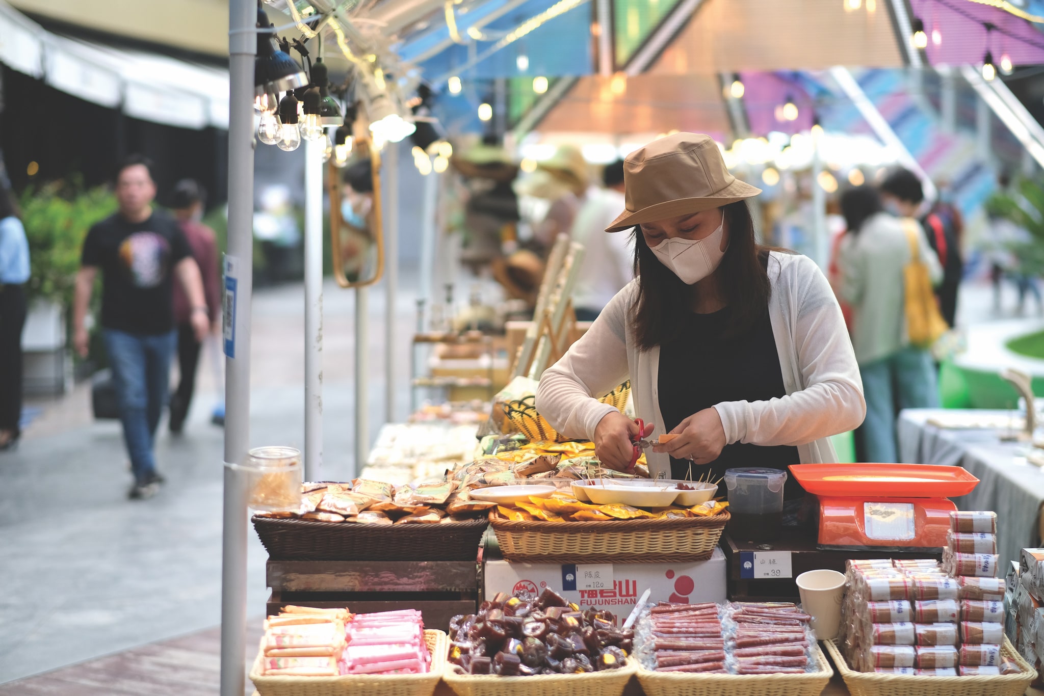 Woman wearing mask prepares dishes in food market