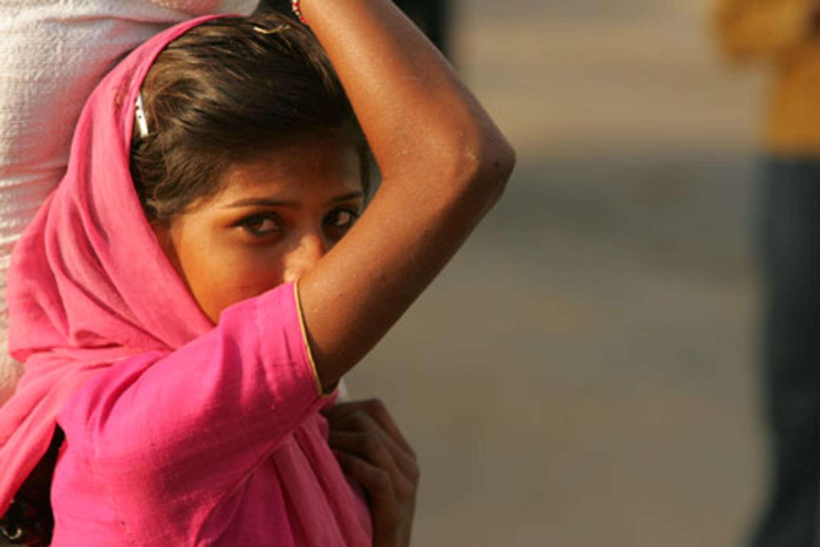 A young Indian girl carries a sack.