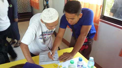 An elderly MILF supporter is assisted in filling out a voter’s registration form during the registration of MILF central committee members and supporters in Maguindanao on March 7.