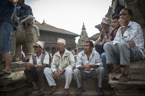 Men sit down inside Durbah Square in Bhaktapur while watching a traditional dance. Photo/Conor Ashleigh 