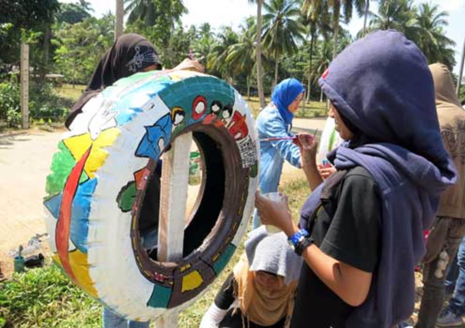 The event attracted young artists from the area who showcased their talents in a variety of forms, including tire painting, above, to promote messages of peace and unity. 